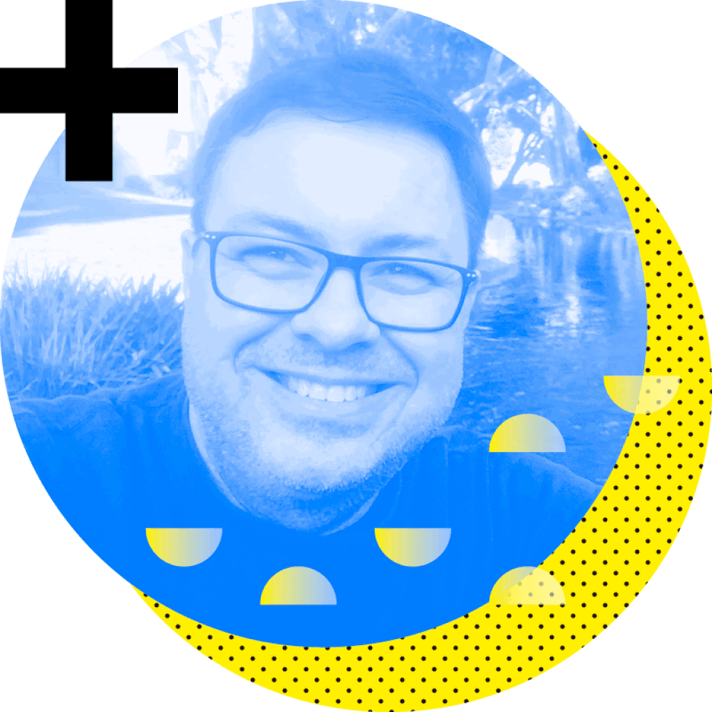 Um homem de óculos está sorrindo diante de um fundo azul e amarelo.