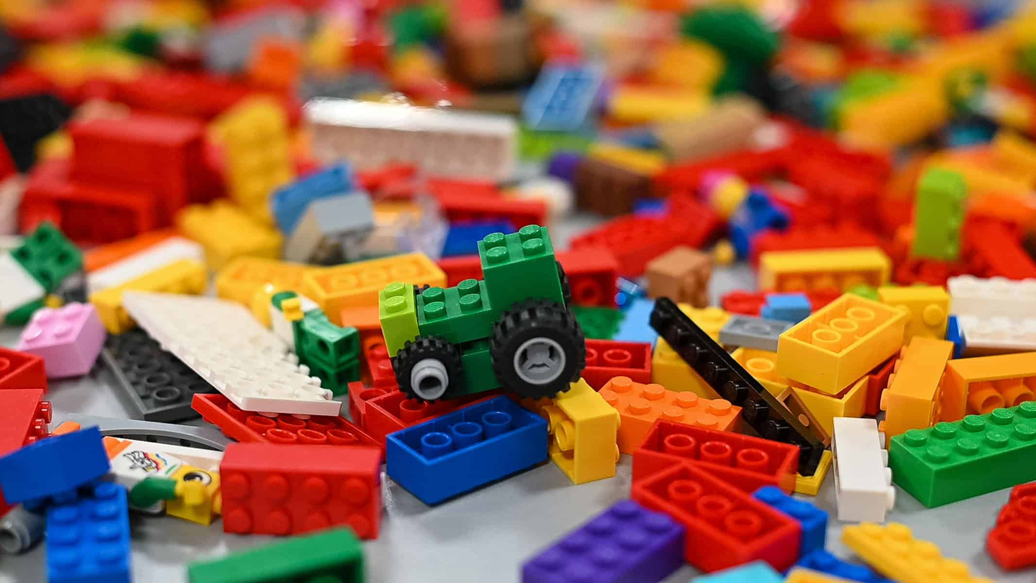 Uma pilha colorida de peças de lego sobre uma mesa.